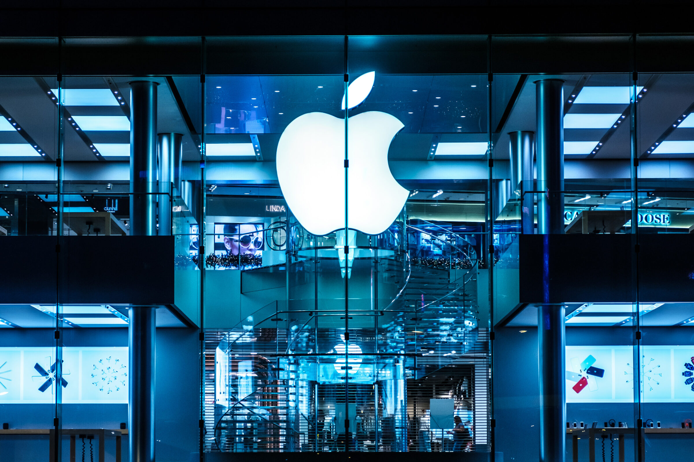 Bright image of the Apple logo on a glass building.